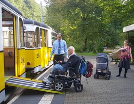 Rollstuhlfahrer und Kinderwagen beim Einstieg in die Kirnitzschtalbahn